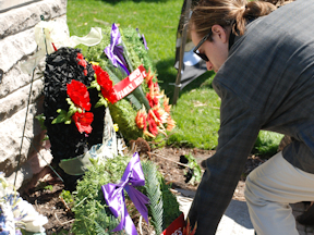 Mourner lays a wreath during an Ontario Day of Mourning ceremony