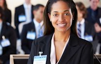 A smiling woman wearing a blazer and nametag