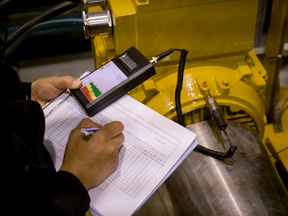 Worker recording data vibration measurement of motor or equipment in power plant